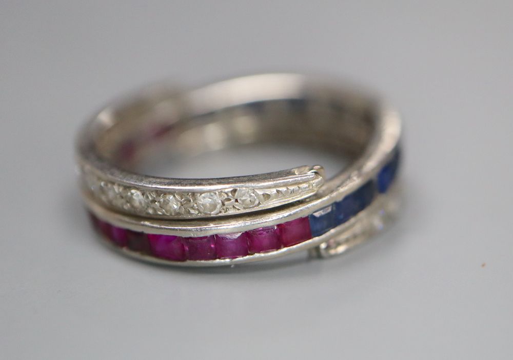 A white metal, diamond, ruby and sapphire swivelling eternity ring (ruby missing), size K, gross 5 grams.